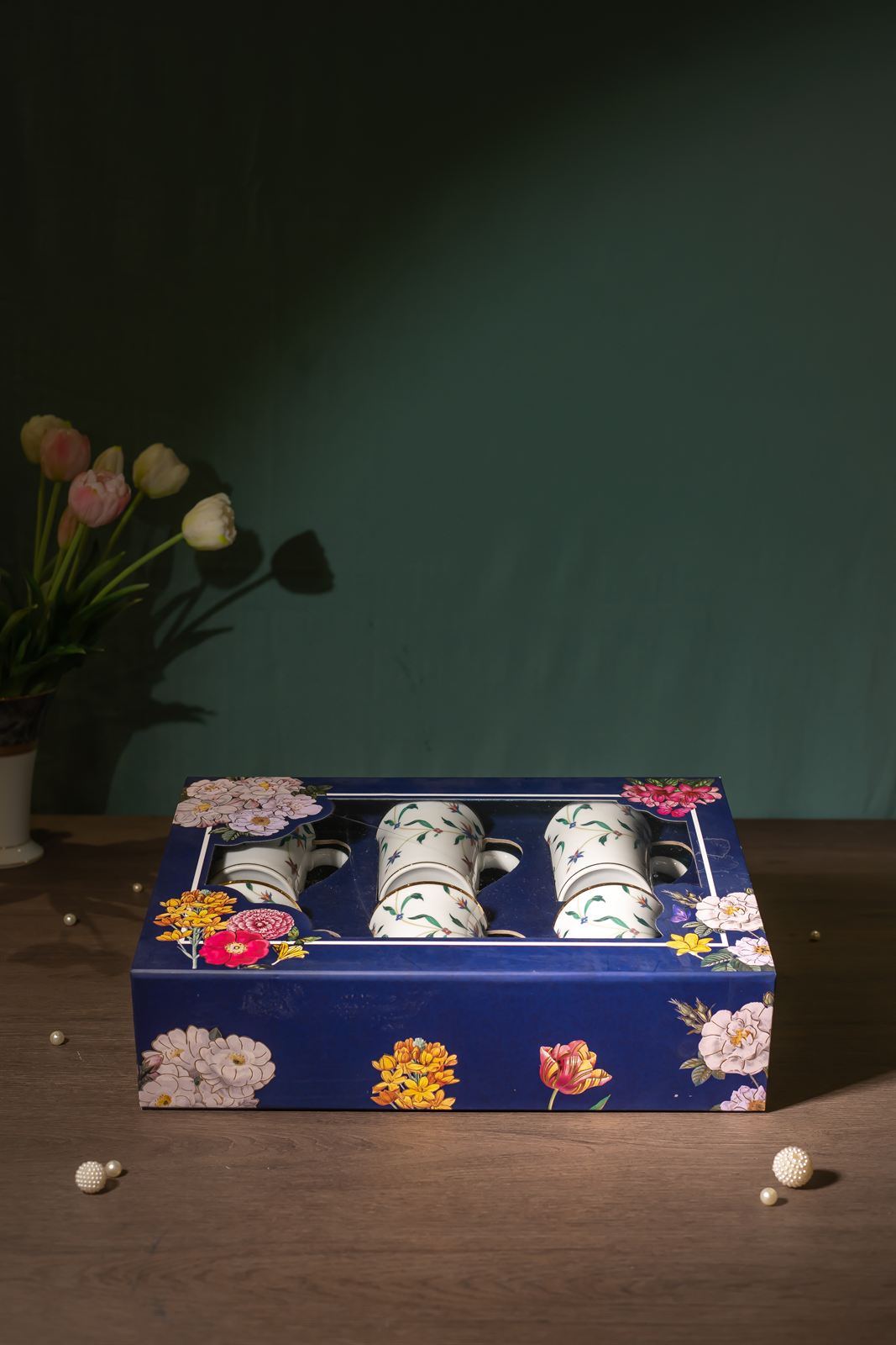 Navy illustrated gift box against a deep teal wall
